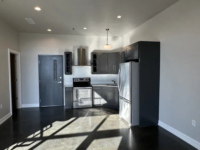 a kitchen with stainless steel appliances a refrigerator and a stove top oven