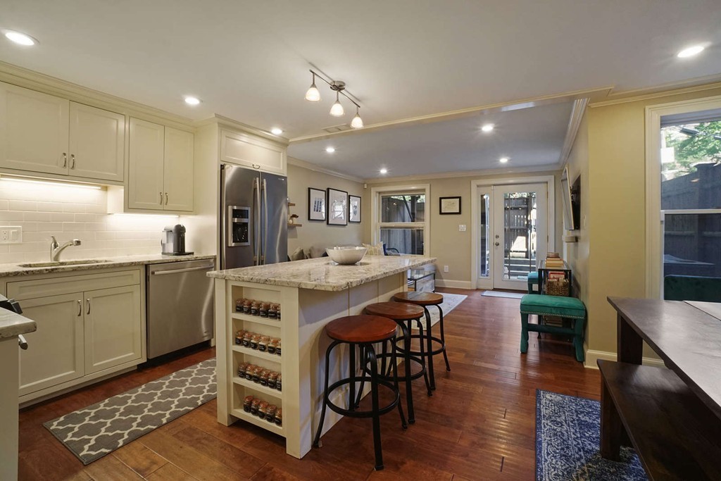 a kitchen with stainless steel appliances granite countertop a kitchen island a stove a table and chairs in it