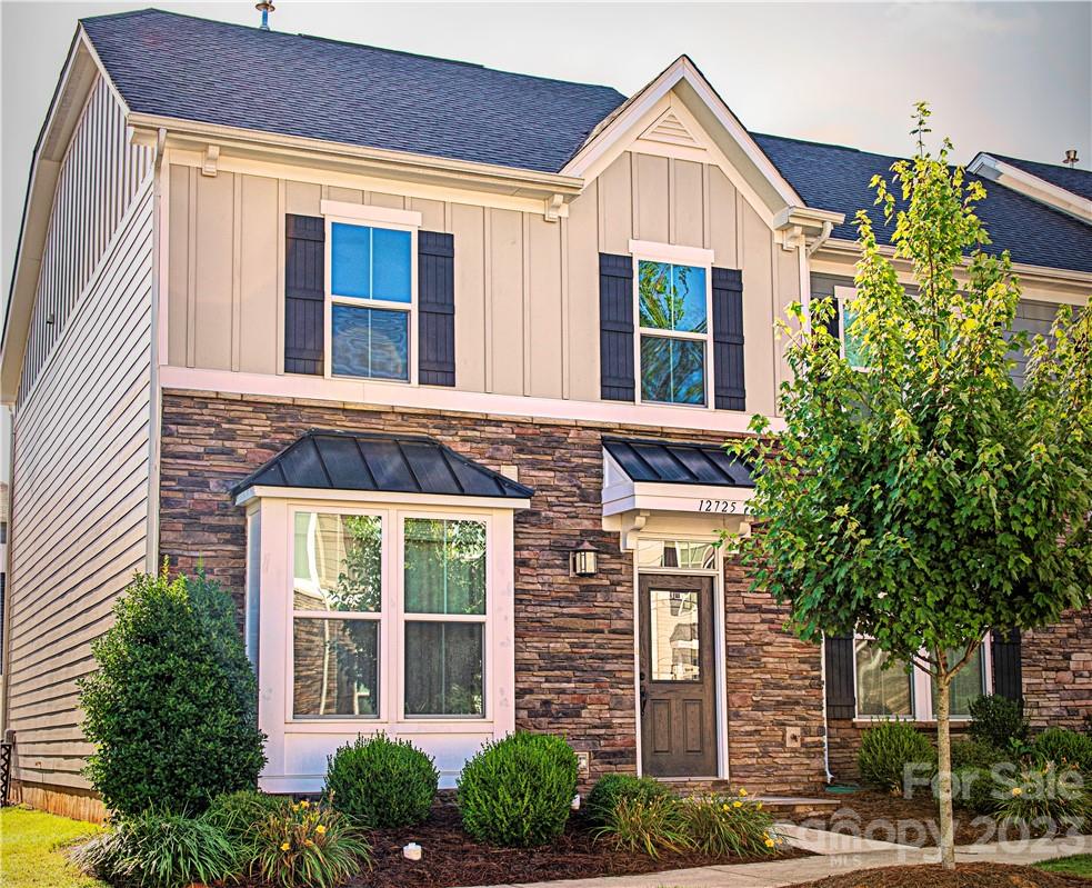 12725 Glowing Peak Road Huntersville, NC 28078 - Photo 1 of 17 a view of a brick house with large windows and a tree
