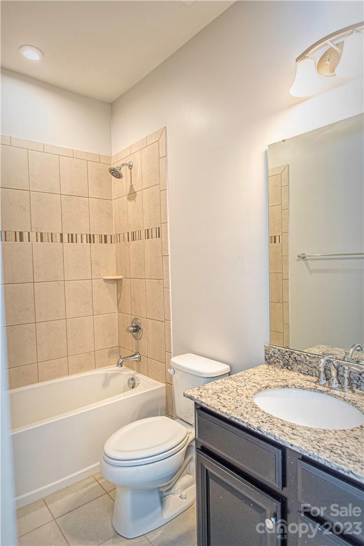 12725 Glowing Peak Road Huntersville, NC 28078 - Photo 12 of 17 a bathroom with a granite countertop sink a toilet and bathtub