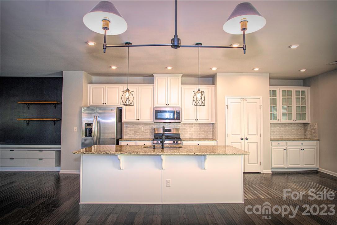 12725 Glowing Peak Road Huntersville, NC 28078 - Photo 4 of 17 a living room with stainless steel appliances kitchen island granite countertop furniture and a kitchen view