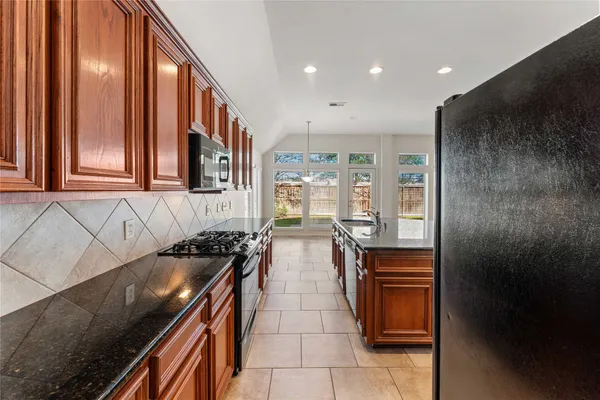 a kitchen with stainless steel appliances granite countertop a stove and a refrigerator