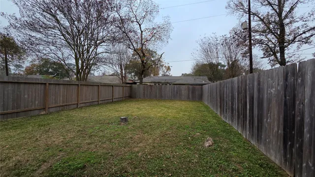 a view of a backyard with wooden fence