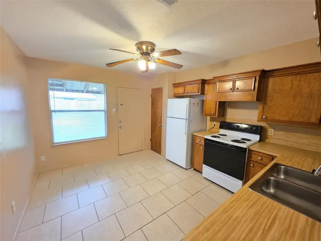 a kitchen with stainless steel appliances granite countertop a refrigerator and a stove top oven