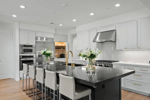a kitchen with stainless steel appliances a stove a sink dishwasher and cabinets with wooden floor