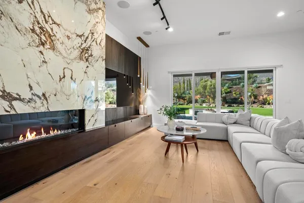 a living room with fireplace furniture and a large window