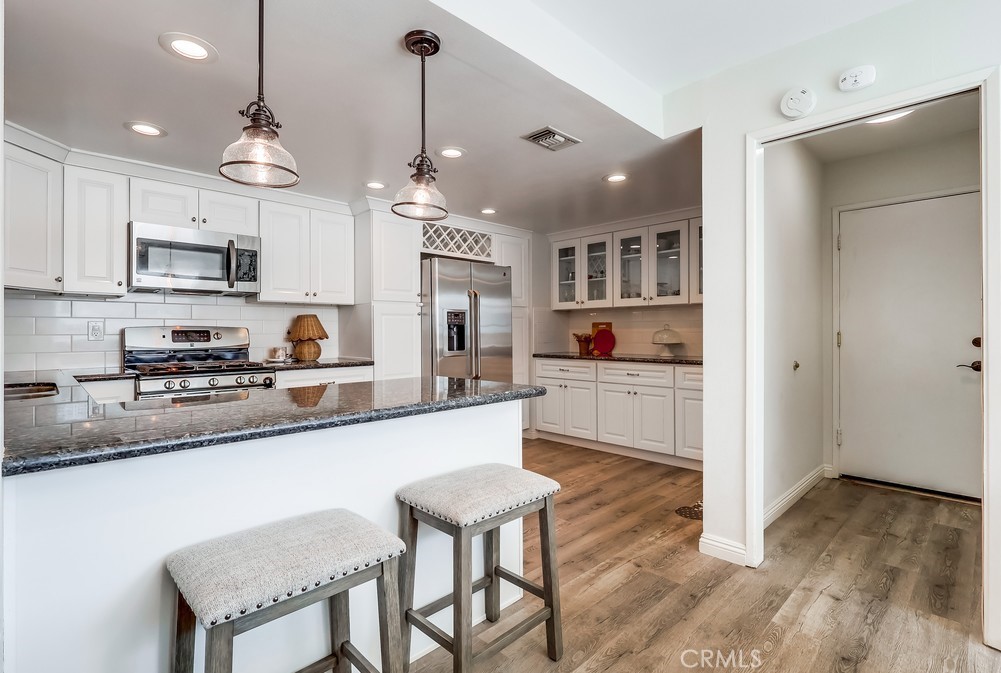 930 Ocean View Avenue, Unit E Monrovia, CA 91016 - Photo 13 of 36 a kitchen with stainless steel appliances granite countertop a sink a stove a refrigerator cabinets and a dining table