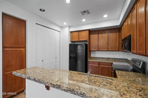 a kitchen with stainless steel appliances granite countertop a refrigerator and a sink