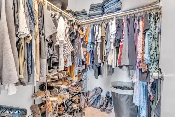 a view of walk in closet with clothes and shoes