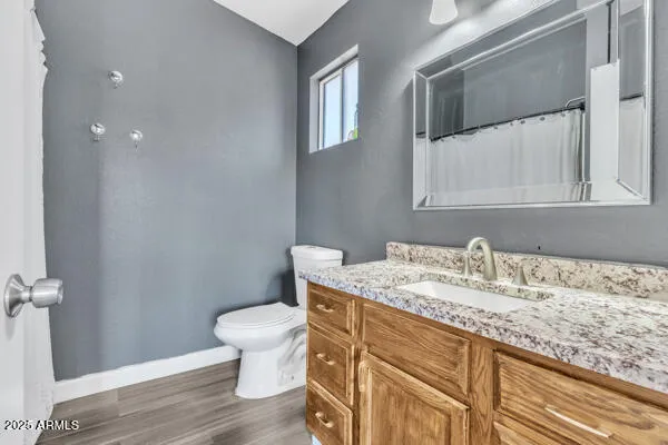 a bathroom with a granite countertop sink mirror vanity and toilet