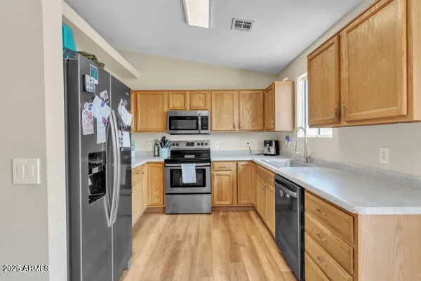 a kitchen with stainless steel appliances granite countertop a refrigerator stove top oven and sink