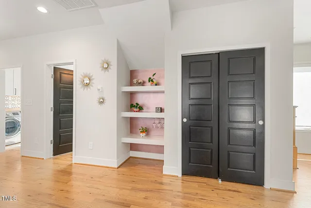 a view of an empty room with wooden floor and closet