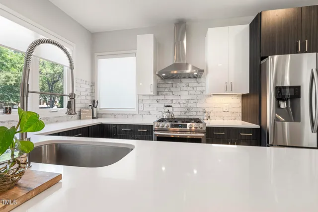 a kitchen with stainless steel appliances a sink a counter space and a window
