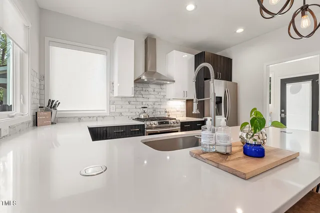 a kitchen with kitchen island granite countertop a sink appliances and cabinets