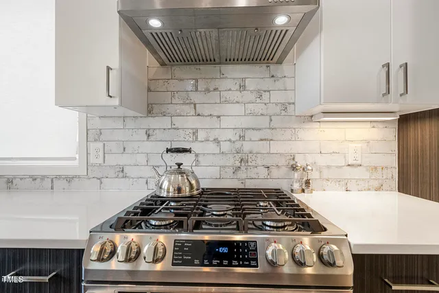 a stove top oven sitting inside of a kitchen