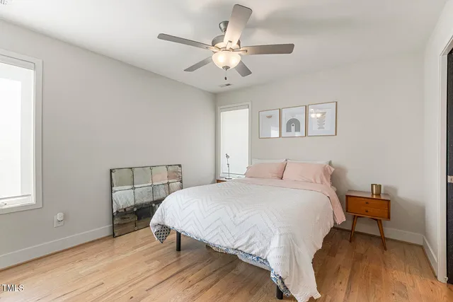 a bedroom with a bed a chandelier and a window