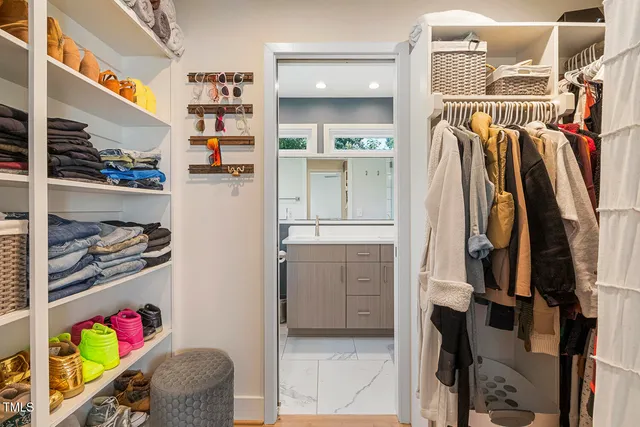 a view of walk in closet with clothes and shoes