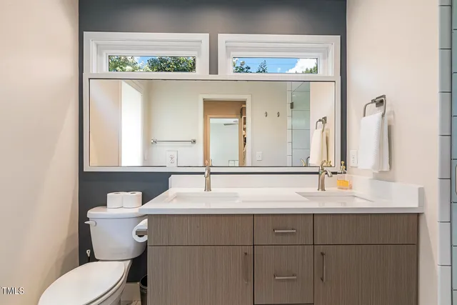 a bathroom with a toilet sink and mirror