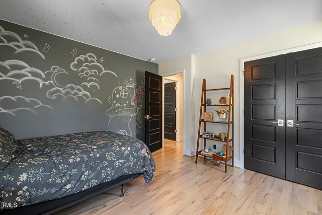 a bedroom with a bed and a chandelier