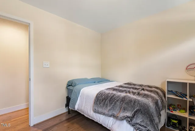 a bedroom with a bed and wooden floor