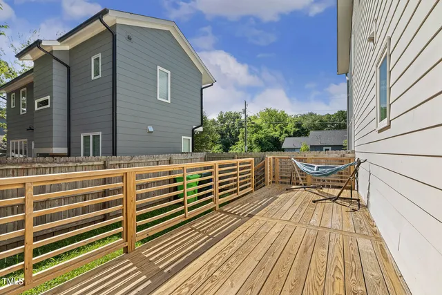 a balcony with wooden floor table and chairs