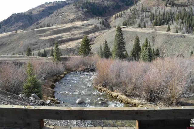 a view of a yard with wooden fence