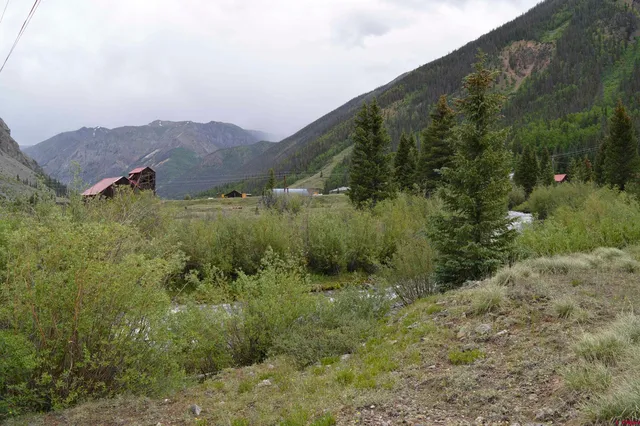 a view of a lush green hillside and a building