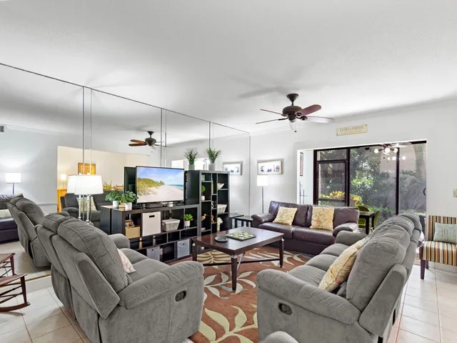 a living room with furniture kitchen view and a chandelier