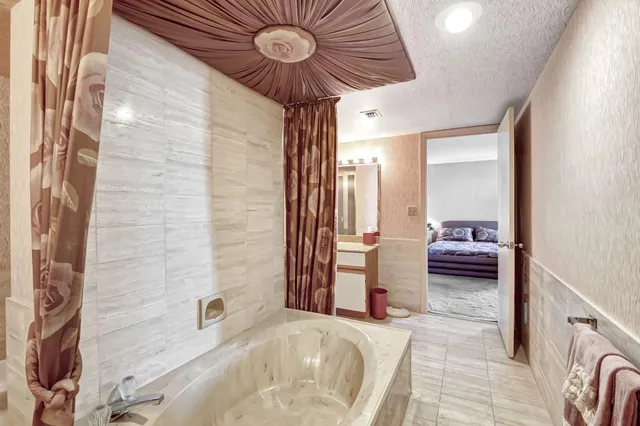 a bedroom with a bed and a chandelier