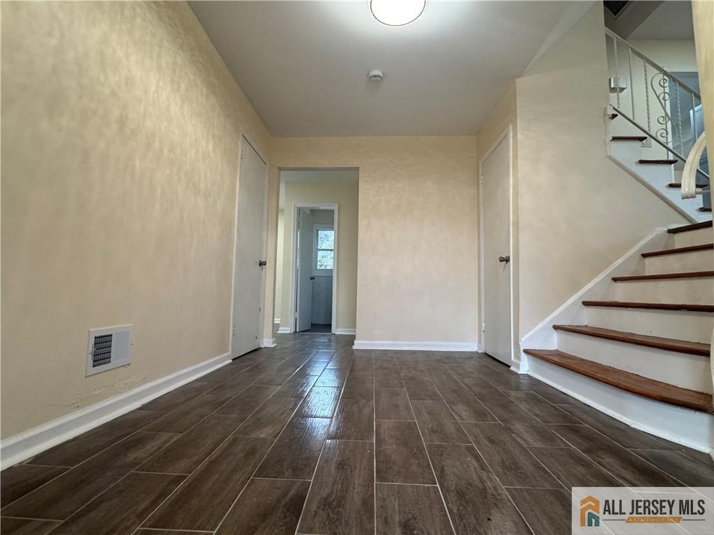 1868 Oak Tree Road Edison, NJ 08820 - Photo 4 of 24 a view of an empty room with wooden floor and stairs