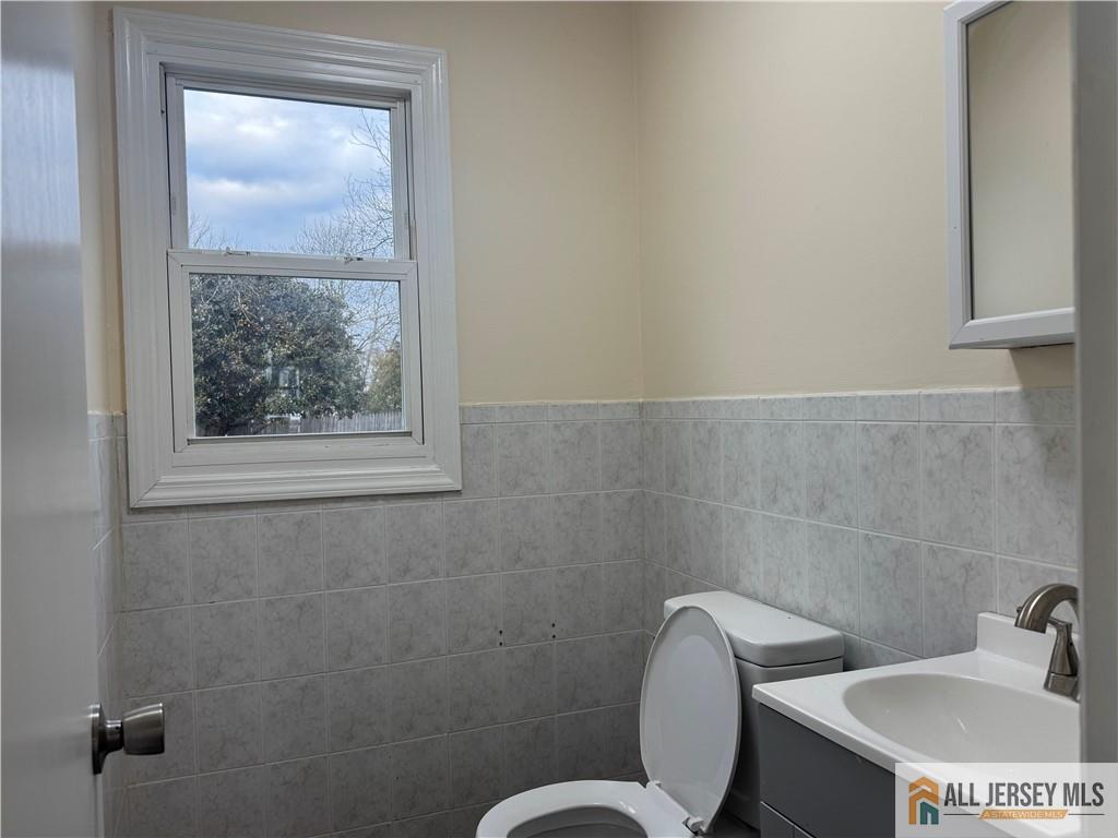 1868 Oak Tree Road Edison, NJ 08820 - Photo 8 of 24 a bathroom with a toilet a sink and mirror