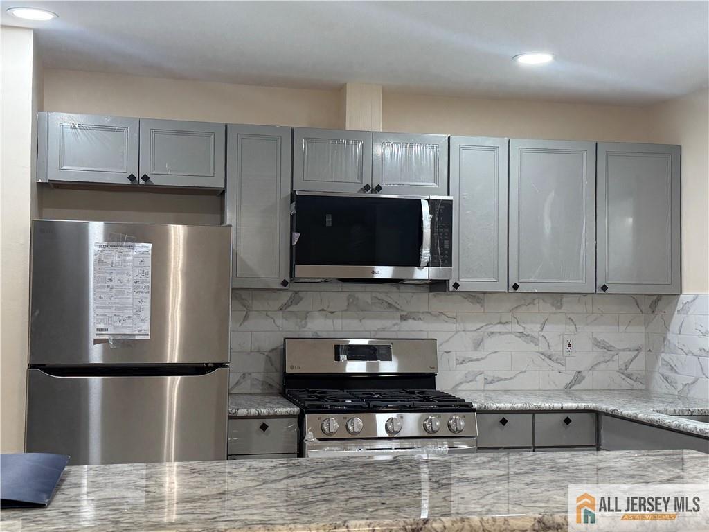 1868 Oak Tree Road Edison, NJ 08820 - Photo 9 of 24 a kitchen with stainless steel appliances granite countertop a stove a refrigerator and a microwave