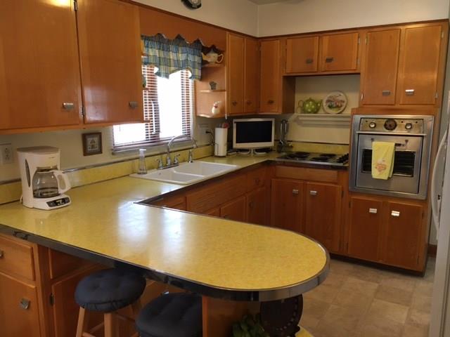 1622 Rostraver Road Belle Vernon, PA 15012 - Photo 10 of 24 Kitchen with Wooden Cabinets and Wrap-around Two-Seater Counter Bar.