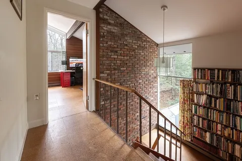a view of a hallway with wooden floor and staircase