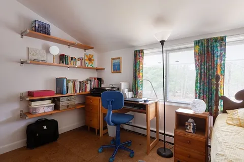 a view of a workspace with furniture and a window