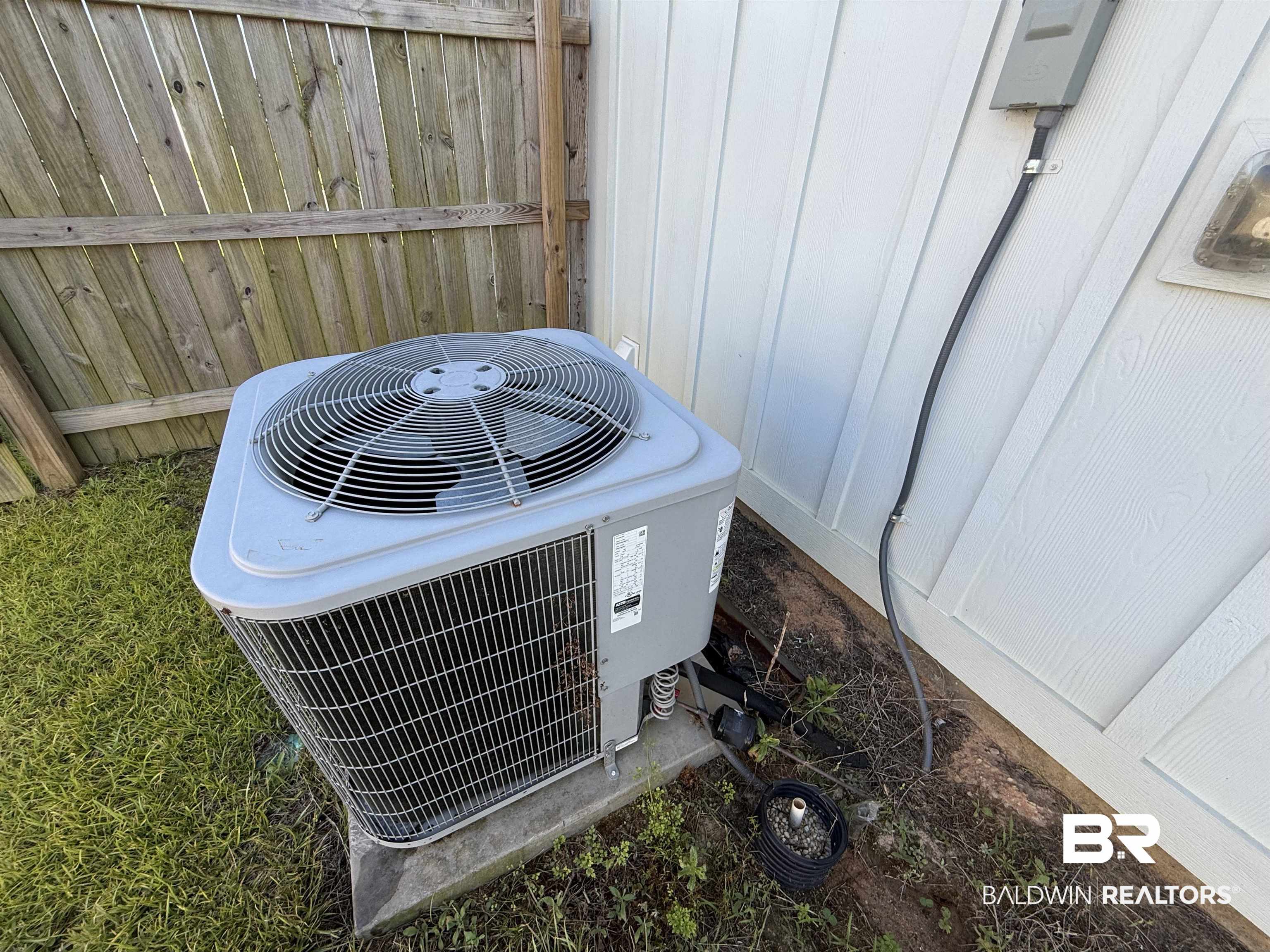 23247 Lieutenant Avenue Foley, AL 36535 - Photo 42 of 47 Outdoor HVAC unit situated on a concrete pad, adjacent to wood fencing and white siding