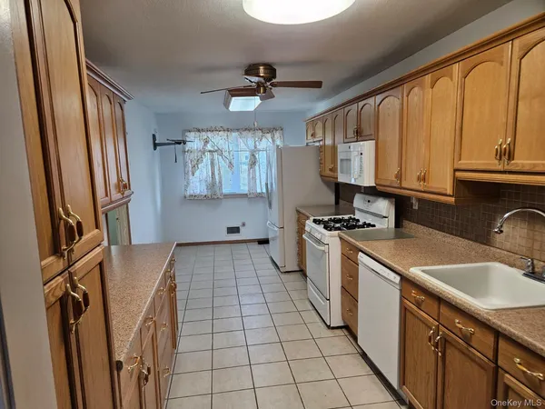 a kitchen with a sink appliances cabinets and a window