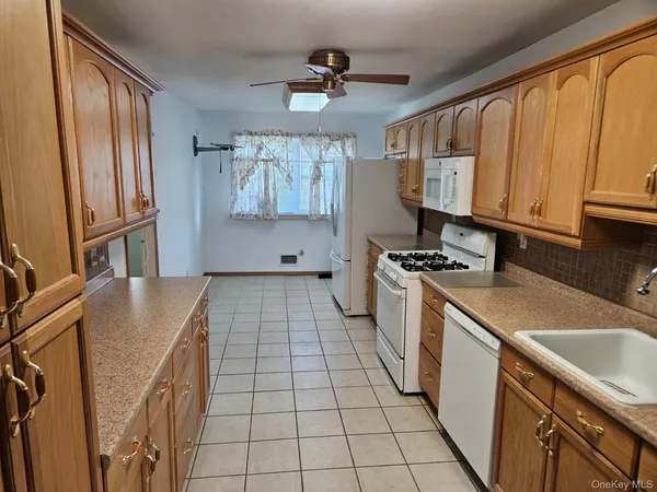 a kitchen with a sink a stove cabinets and a window