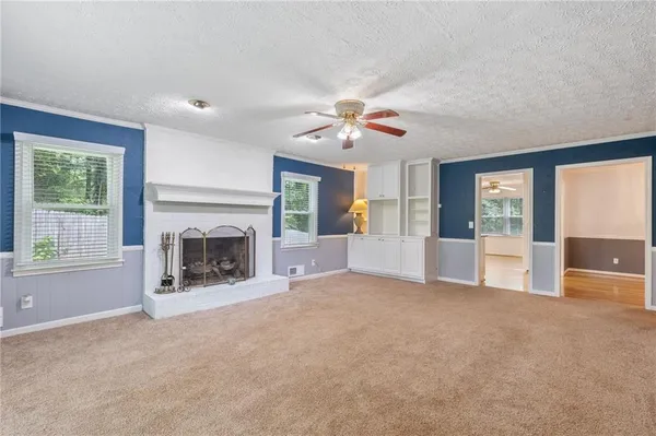 a view of an empty room with a fireplace and a window