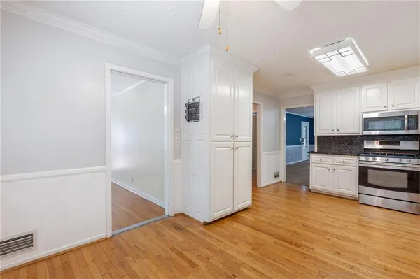 a kitchen with granite countertop a stove a sink and a microwave
