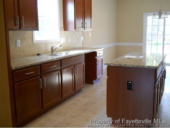 732 Sun Road Aberdeen, NC 28315 - Photo 3 of 7 a kitchen with stainless steel appliances granite countertop a sink and a refrigerator