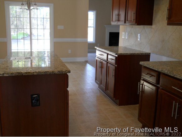 732 Sun Road Aberdeen, NC 28315 - Photo 5 of 7 a kitchen with stainless steel appliances granite countertop a stove a sink and a microwave