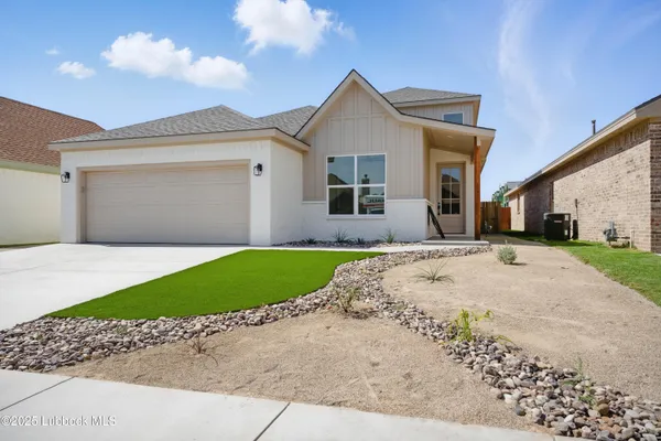a front view of a house with a garden and yard