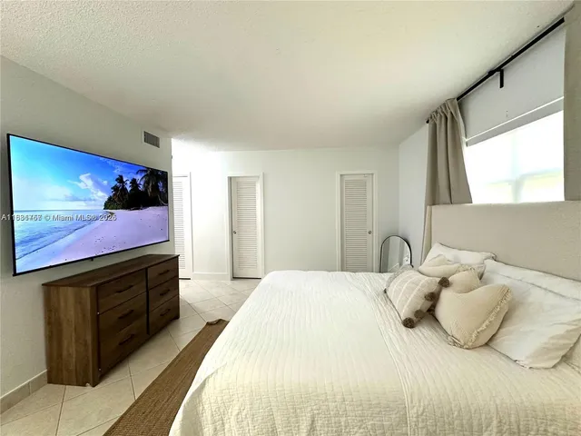 a bedroom with a bed and a flat screen tv
