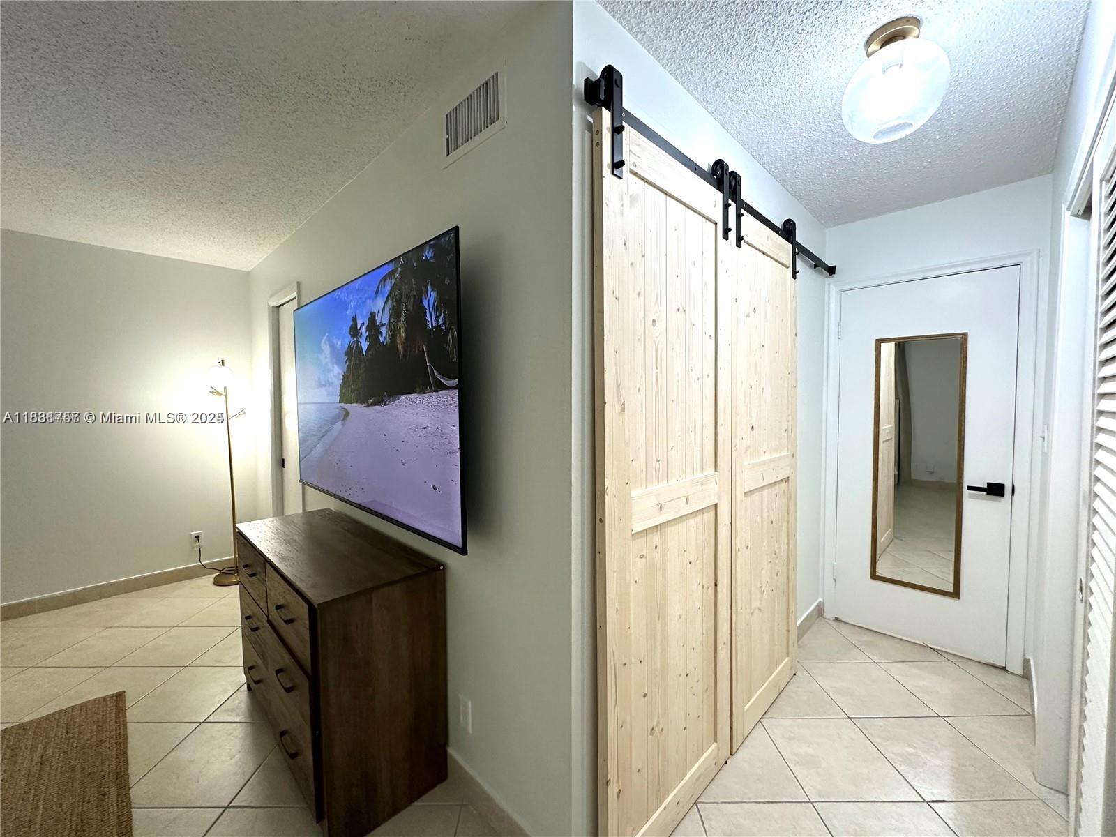 620 Northeast 12th Avenue, Unit 102 Hallandale Beach, FL 33009 - Photo 14 of 23 a view of a hallway with paintings on the wall