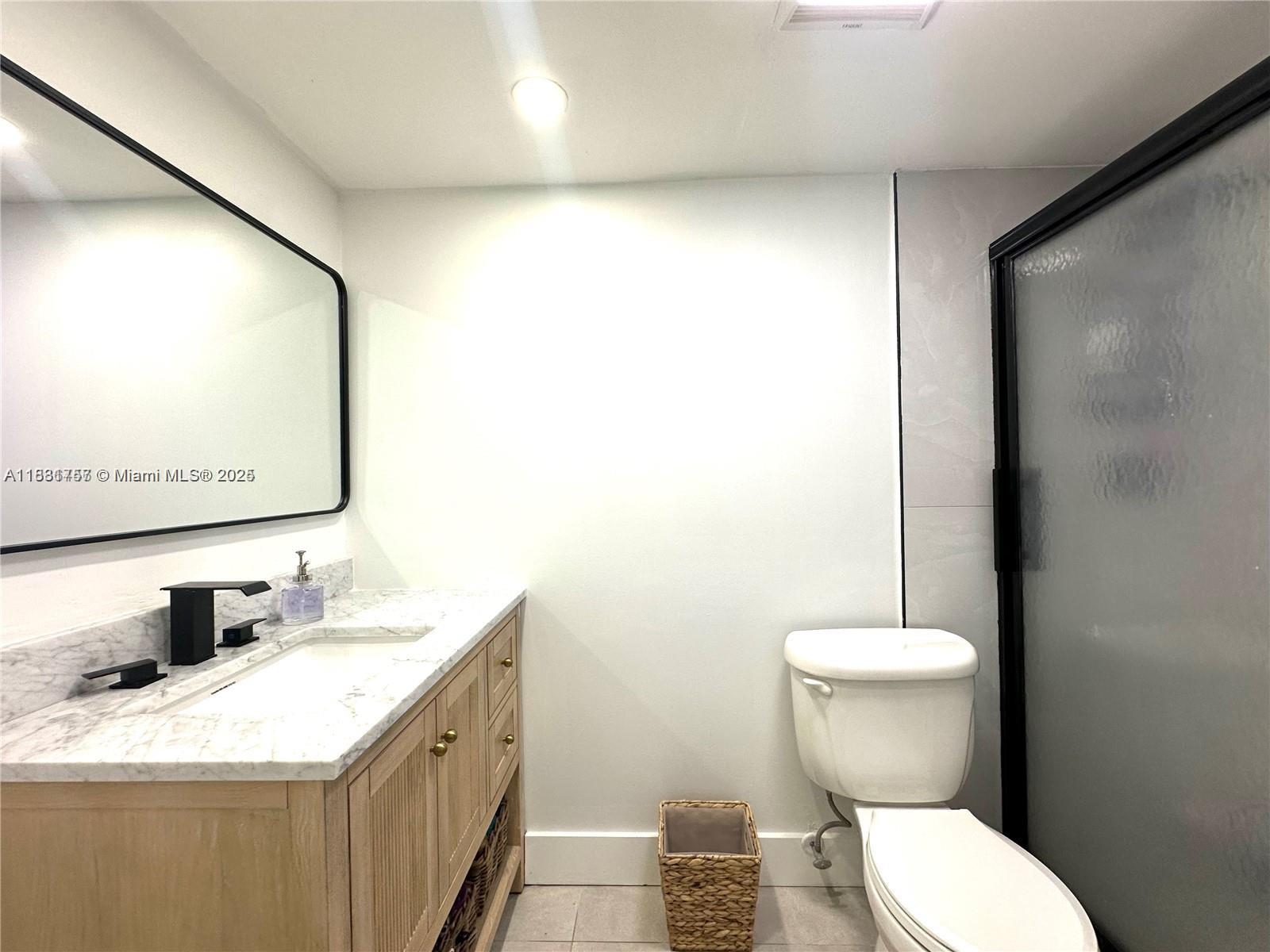 620 Northeast 12th Avenue, Unit 102 Hallandale Beach, FL 33009 - Photo 15 of 23 a bathroom with a granite countertop sink mirror vanity and toilet