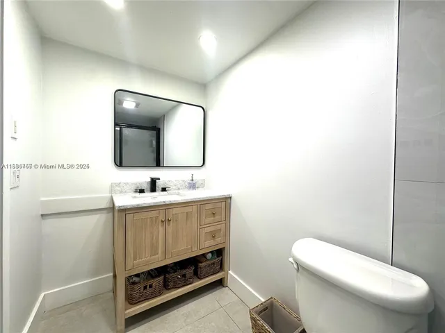 a bathroom with a toilet a sink and mirror