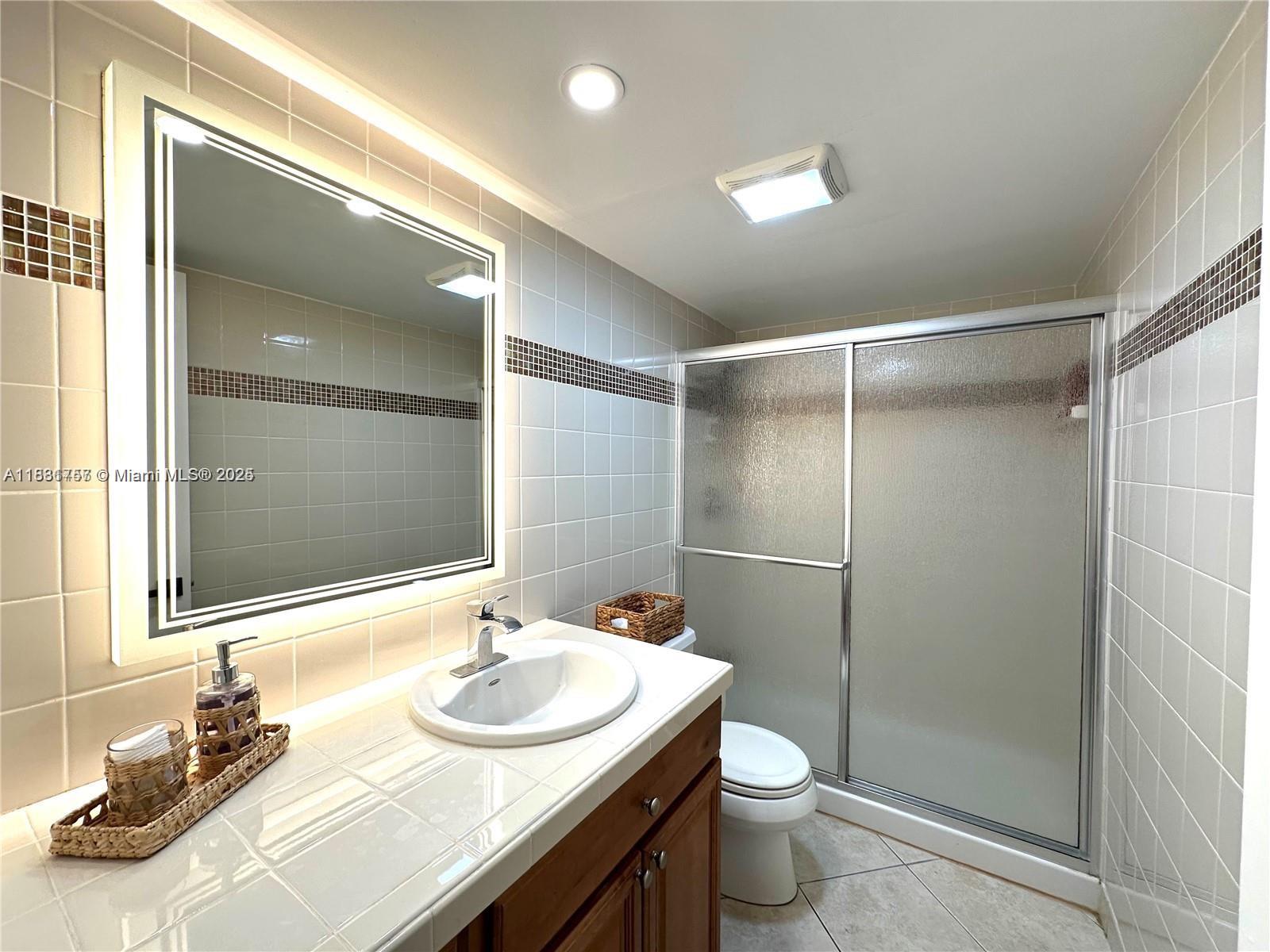 620 Northeast 12th Avenue, Unit 102 Hallandale Beach, FL 33009 - Photo 20 of 23 a bathroom with a sink and a mirror