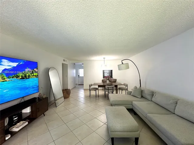 a living room with furniture a floor to ceiling window and a flat screen tv