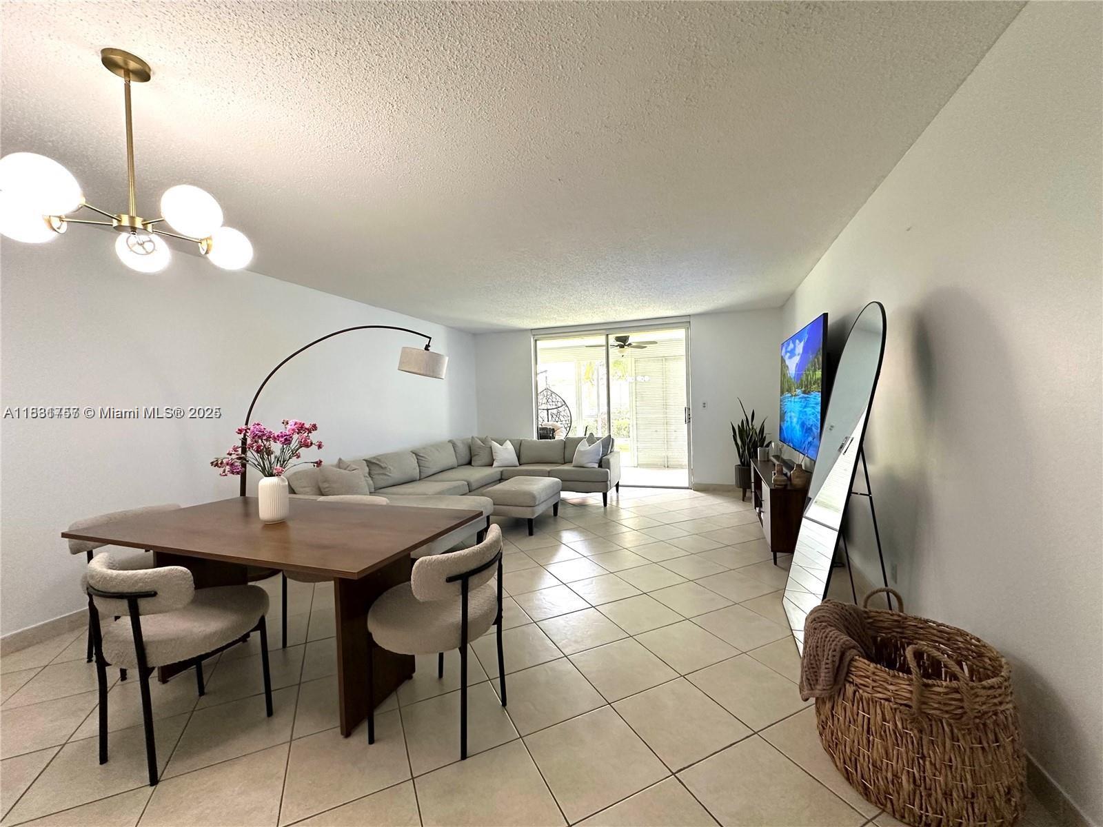 620 Northeast 12th Avenue, Unit 102 Hallandale Beach, FL 33009 - Photo 3 of 23 a view of a dining room with furniture and chandelier